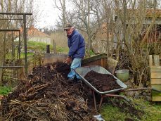 Mann bei Kompost umgraben